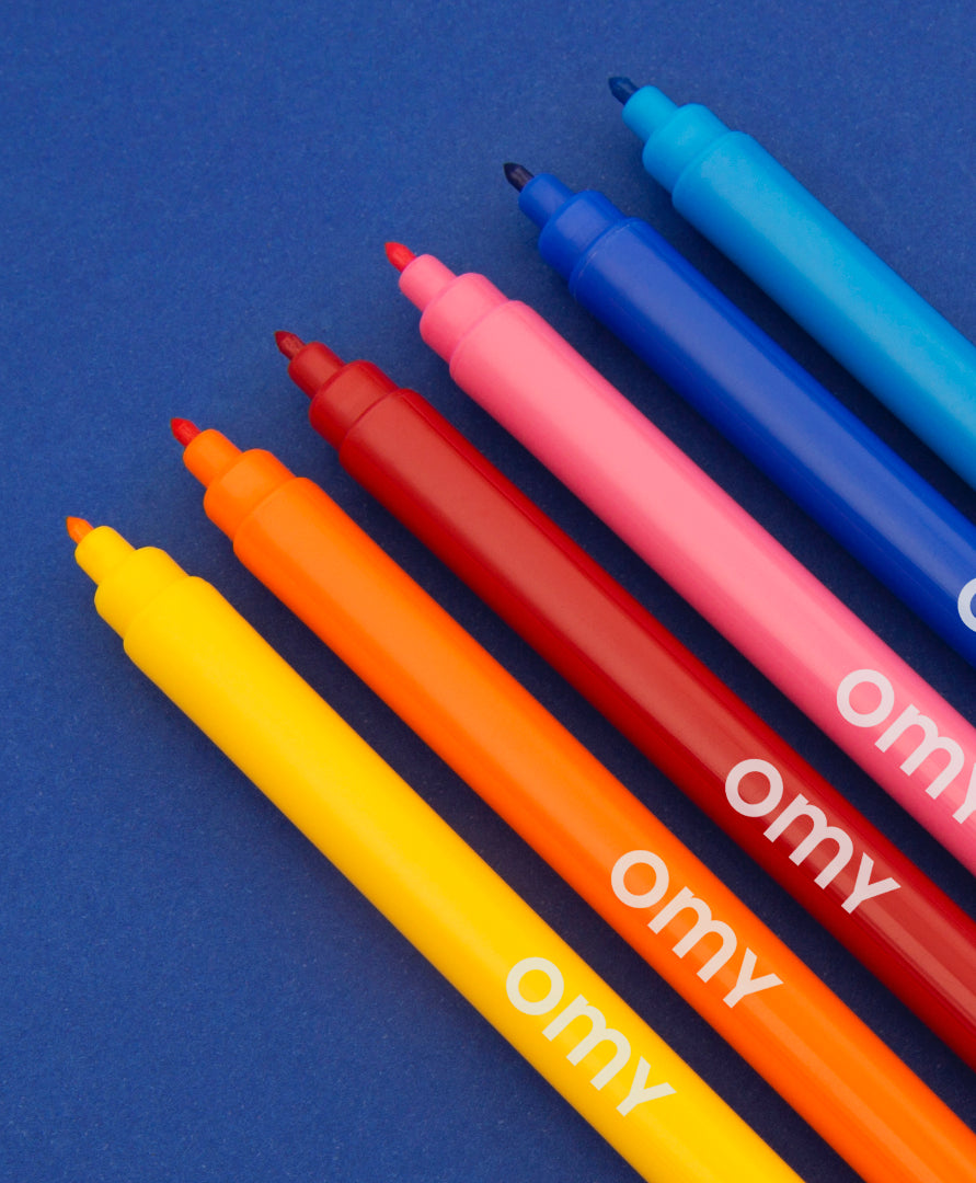 Colorful markers with 'omy' branding on a blue background