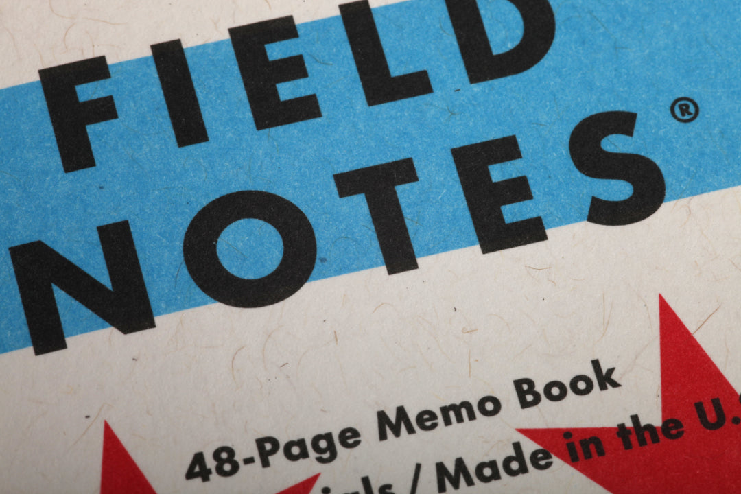 Close-up of a Field Notes memo book packaging with blue and red accents.