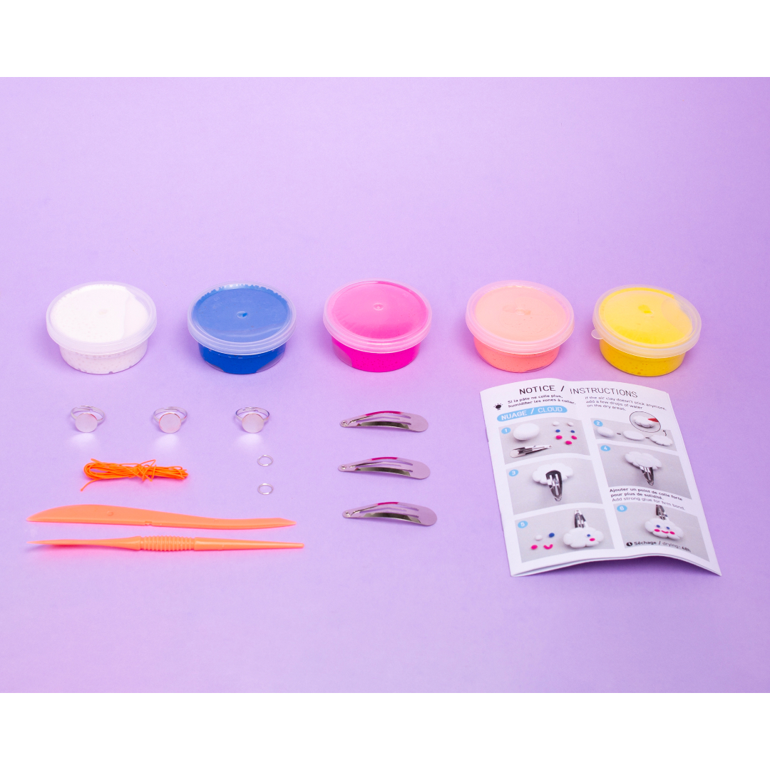 Set of craft supplies including containers, tools, and a instruction sheet on a purple background