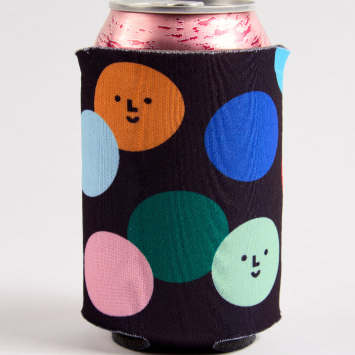 Can with a black sleeve featuring colorful polka dots on a white background