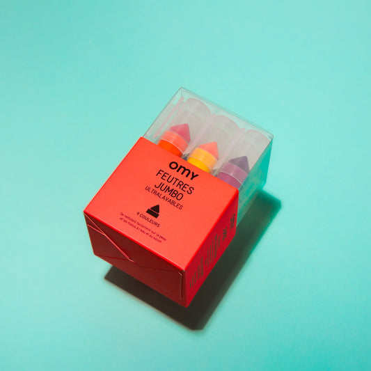 Box of OMY colorful felt-tip pens with a red label on a light blue background