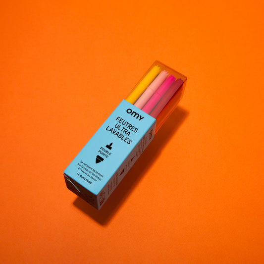 Box of colorful markers with 'omy' branding on an orange background