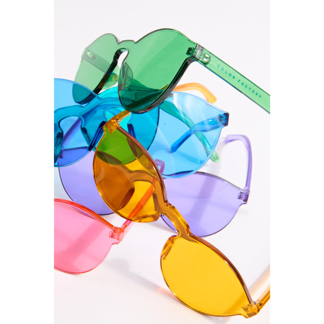 Colorful sunglasses with green, blue, orange, and pink frames on a white background