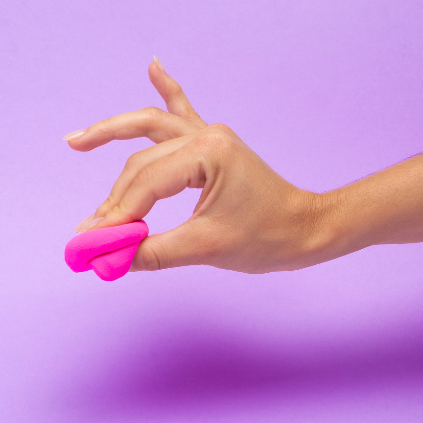 Hand holding pink 'do' against a purple background
