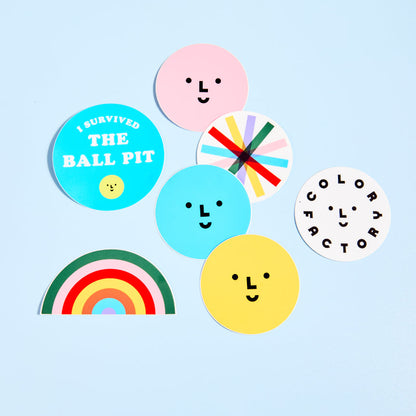 Colorful stickers with smiley faces and text on a light blue background