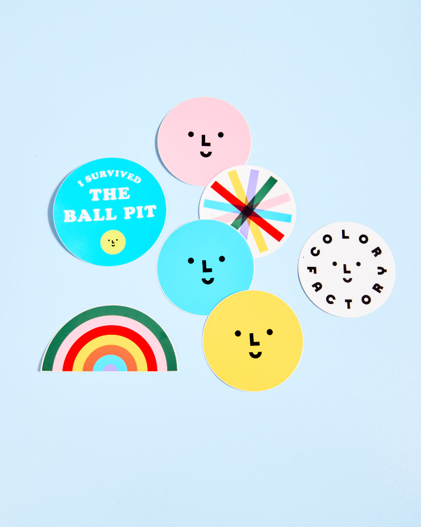 Colorful stickers with smiley faces and text on a light blue background