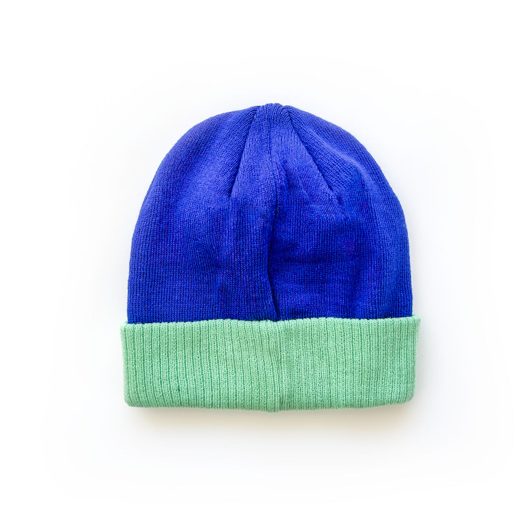 blue beanie with a folded mint colored brim on a white background